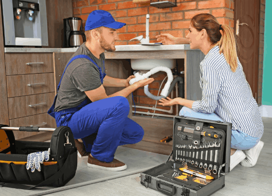 Plumber explaining completed plumbing work to a homeowner